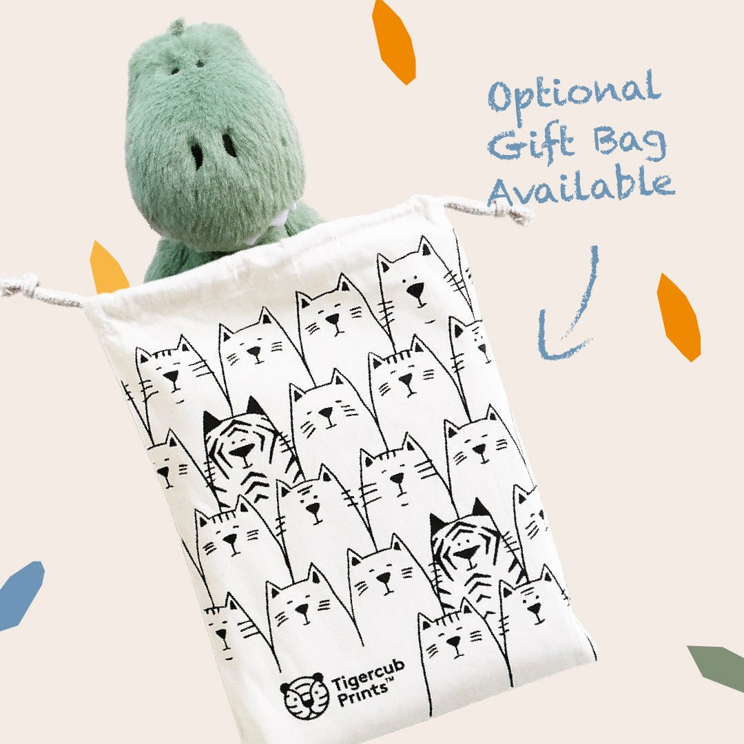And image showing the optional gift bag available when buying the green T-Rex plush toy - the bag is a neutral cotton drawstring bag with an illustration of some tigers hiding amongst a group of kittens on the bag and the Tigercub Prints brand in the bottom corner